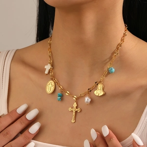 Close-up of gold stainless steel necklace with religious cross and Mary pendants