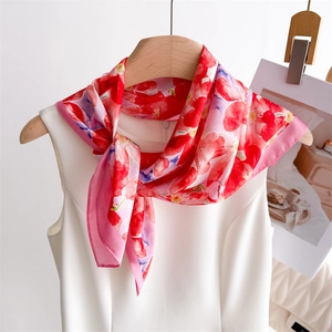 Vue détaillée d'un foulard en soie à fleurs élégant noué sur un chemisier blanc chic