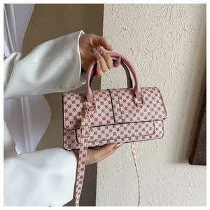 Detail shot of pink crossbody bag with vintage circular pattern and gold hardware accents