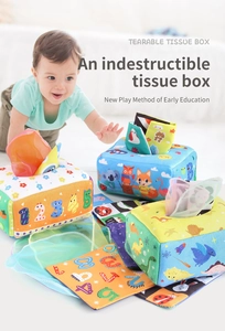 Infant reaching for soft sensory tissue box toy with colorful dinosaur and animal prints