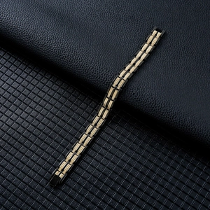 Detail shot of men's black and gold wheat pattern magnetic therapy bracelet with folding clasp