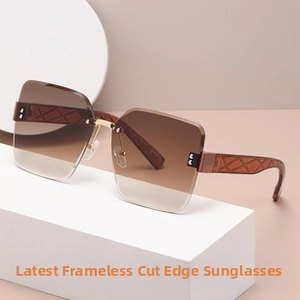 Detailed close-up of rimless sunglasses with brown gradient lenses and textured temples