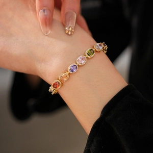 Detailed close-up of vintage gold bracelet with colorful oval zircons and micro-pave setting