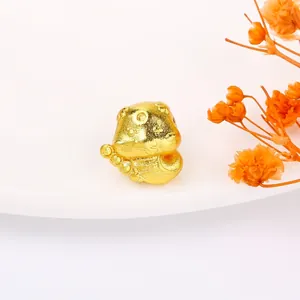 Macro view of a matte gold-plated cute beast charm for DIY jewelry on a white plate