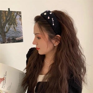 Detail of a black plush headband with sparkling rhinestones worn on a model's head