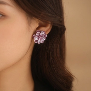 Elegant purple double-layered resin flower stud earrings worn by a model in soft light