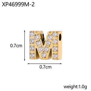 Detailed view of micro-paved gold letter M pendant with sparkling cubic zirconia stones