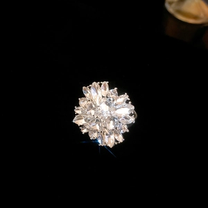 Close-up of silver flower cluster ring with sparkling marquise and round crystals on black