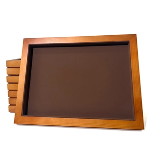 Detail of walnut wood jewelry tray with brown velvet lining for elegant necklace display