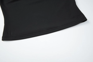 Detailed close-up of double-stitched hem and black knit fabric on a French style top