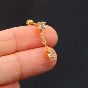 Macro shot of gold ear bone stud with zircon chain and screw ball back closure