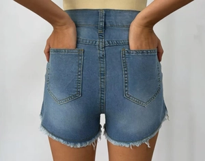 Detail of high waisted light blue denim shorts with back pockets and frayed raw edges