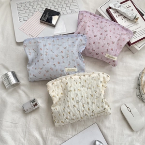 Ensemble détaillé de trousses de toilette à fleurs en bleu, rose et blanc avec texture