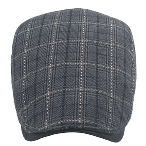 Detail of grey plaid flat cap fabric showing classic windowpane pattern texture