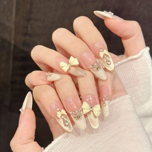 Luxurious almond-shaped press-on nails with 3D bows and pearls in soft nude tones