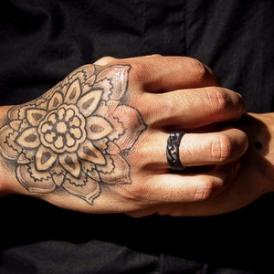Men's black stainless steel Cuban link chain ring worn on a tattooed hand, street style