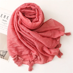 Macro detail of coral pink cotton linen scarf with shiny silver lurex and tassel edges