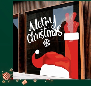 Detail of Santa hat and Peace sign static window decals on a dark glass surface