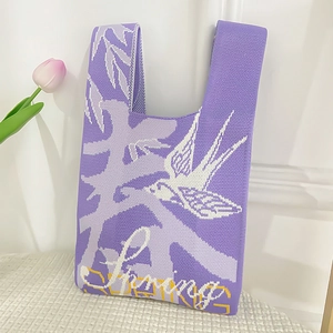 Detailed knit of purple tote bag featuring woven swallow patterns and Spring text