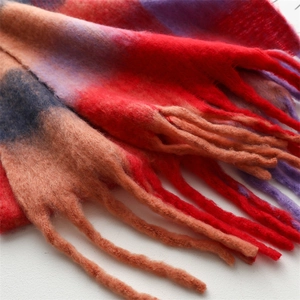 Close-up of thick gradient plaid scarf showing soft mohair texture and long tassel fringe