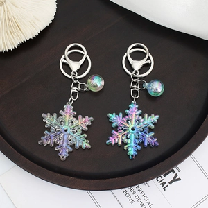 Colorful acrylic snowflake keychain with iridescent finish and metal bell accessory