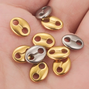 Stainless steel coffee bean oval connectors in gold and silver on a palm