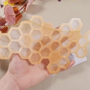 Détail d'un porte-clés en résine alvéolé avec flocons d'or et chaîne délicate