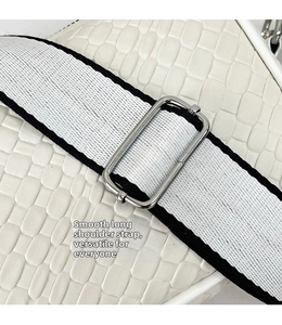 Detail of woven texture white bag with dual-tone canvas strap and silver buckle