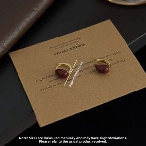 Vue macro de boucles d'oreilles goutte en or 18 carats avec émail rouge et mesure de 1,2 cm