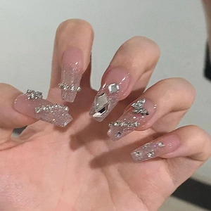 Close-up of pink gradient press-on nails with silver glitter and butterfly charms