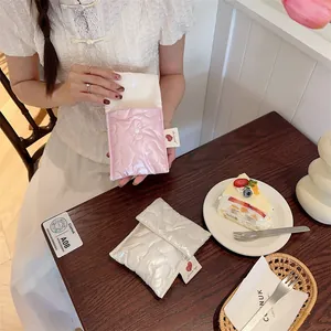 Detail of pink and white quilted heart bags with button closure on a cafe table