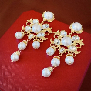 Detailed view of Baroque pearl earrings with crystal inlay on a red leather box