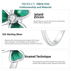 Macro detail of silver clover ring showing green enamel petals and 3A grade zircon stones