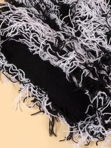 Dettaglio del tessuto a maglia bianco e nero con frange e fibre a trama ruvida