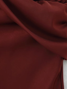 Macro shot of deep red midi dress fabric showing plain weave texture and matte finish