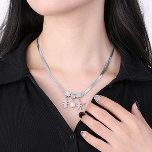 Silver snake chain necklace with boy, girl and pearl charms worn by a model