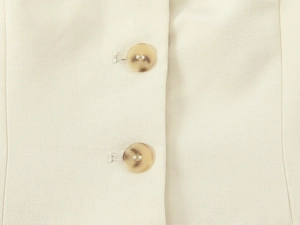 Détail macro de boutons en résine ambrée sur tissu beige mélangé avec une fine texture sergé