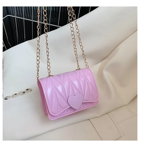Detail of pink heart-shaped silicone bag with gold chain strap and quilted texture