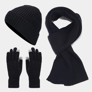 Close-up of black winter knit set including hat, scarf and touchscreen gloves