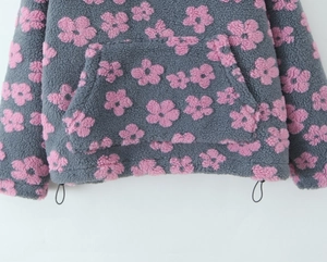 Detail of grey fleece sweatshirt with pink floral print and adjustable drawstring hem