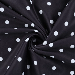 Detaillierte Makroansicht der schwarz-weiß gepunkteten Stofftextur mit glänzendem Finish
