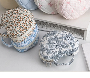 Quilted cotton makeup bags with floral patterns on desk with lifestyle props
