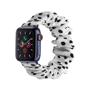 Detail of white scrunchie watch band with black polka dots on a blue smartwatch