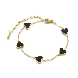 Fashionable gold chain bracelet with five black heart pendants on a clean white background