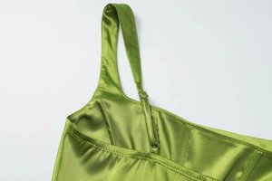 Detail view of green satin dress with adjustable shoulder straps and metallic hardware