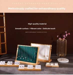 Detailed view of bamboo wood necklace display stand with dark green velvet surface