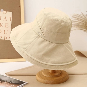 Foldable beige wide brim sun hat for women with minimalist metal emblem decoration