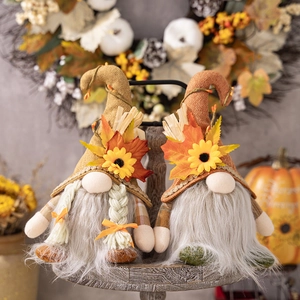 Detail von zwei Herbstwichteln mit Sonnenblumenhüten und grauen Bärten auf Holz