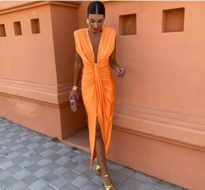Détail de la robe longue en satin orange avec col en V et nœud torsadé à la taille