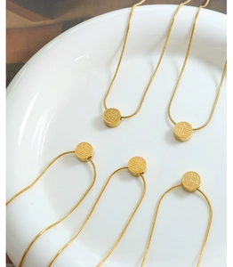 Detailed view of gold plated stainless steel snake chain necklaces with Fu and Xi pendants